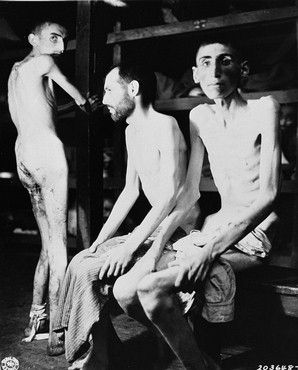 Three emaciated survivors in a barracks in the newly liberated Buchenwald concentration camp